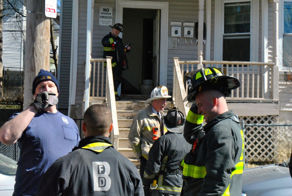 Boston firefighters relax after dousing a small fire in a bathroom in the area of 190 Boylston St. on March 18, 2014.