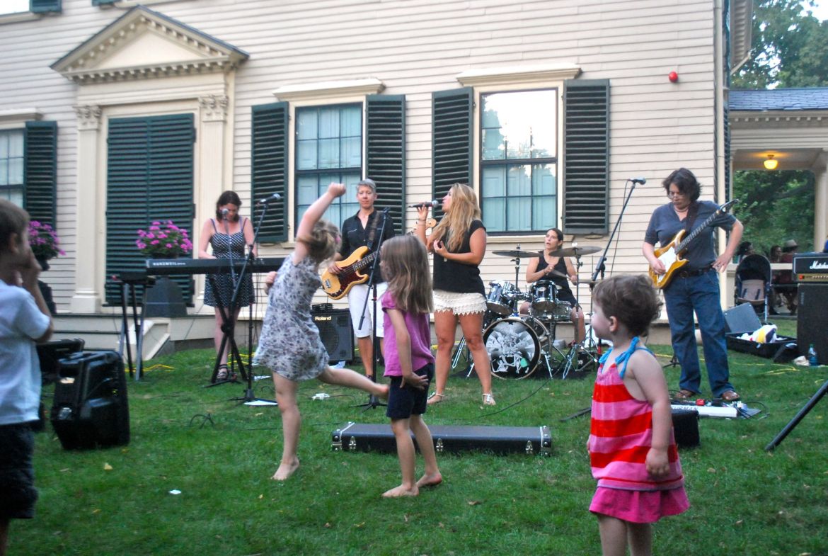 Children dance on the lawn at the Loring-Greenough House to a performance by Gunpowder Gelatine, an all-woman Queen cover band, on Thursday, Sept. 4, 2014.