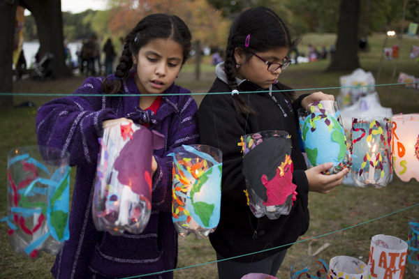 Twins Veronica (left) and Victoria, 9, light lanterns in preparation for the Jamaica Pond Lantern Parade on Oct. 18, 2014. The girls are involved in Spontaneous Celebrations’ La Piñata program, a traditional music and dance group directed by Rosalba Solis.