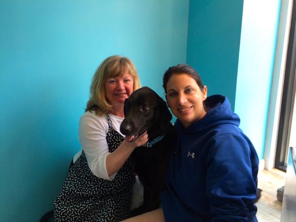 Co-owners Nancy Baxter, left, and Rebecca Wildstein love up on a visiting pup.