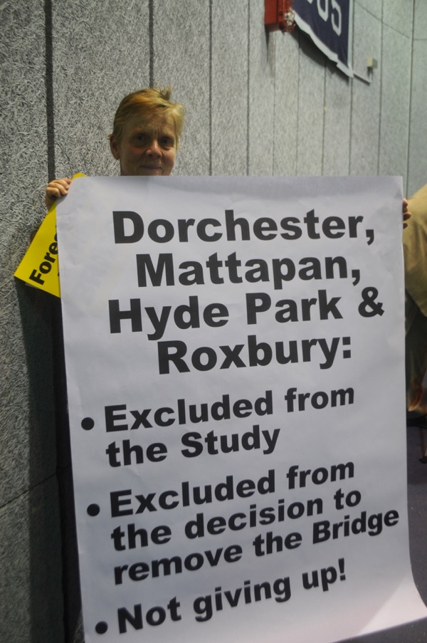 A protester holds up a sign at a May 7, 2015 meeting on the Casey Arborway.