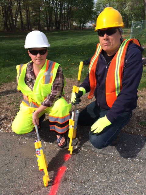 JP residents Andreé Zaleska, left, and Chuck Collins donned road worker gear to carry out a pavement-marking protest of the West Roxbury Lateral Pipeline on Friday, May 15, 2015.