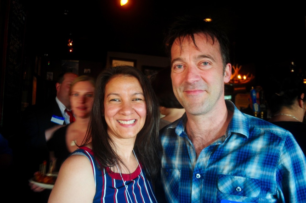Alison Moronta, business development director for the Jamaica Plain Neighborhood Development Association, shares a smile with Jason Waddleton, owner of The Haven, which hosted a meeting of Hyde and Jackson Square business owners on May 13, 2015.