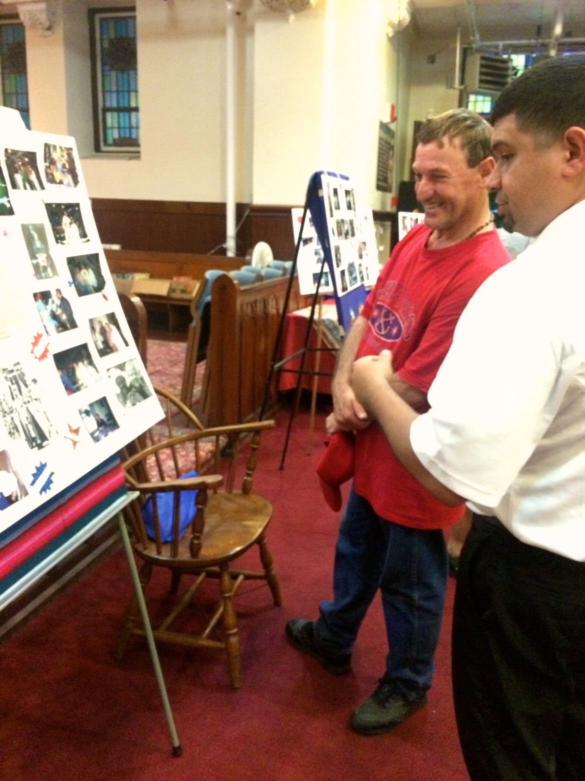 William Morales (far right) looks at photos of the late Father Jack Roussin
